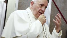 Pope Francis talks aboard the papal plane while en route to Italy September 28, 2015. REUTERS/Tony Gentile 