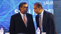 FILE PHOTO: Anil Ambani talks to his brother Mukesh during the launch of Digital India Week in New Delhi