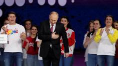 Russian President Vladimir Putin (front) greets the audience at the congress of volunteers in Moscow, Russia December 6, 2017. REUTERS/Sergei Karpukhin