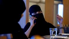 FILE PHOTO: A woman speaks on a mobile phone in a cafe in Riyadh