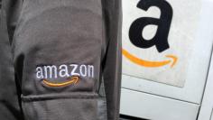 FILE PHOTO: An Amazon.com Inc driver stands next to an Amazon delivery truck in Los Angeles, California, U.S., May 21, 2016. REUTERS/Lucy Nicholson/File Photo 