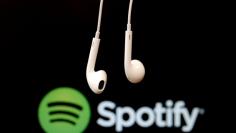 FILE PHOTO: Headphones are seen in front of a logo of online music streaming service Spotify in this  February 18, 2014 illustration picture. REUTERS/Christian Hartmann/File Photo