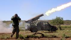 A rebel fighter from the Ahrar al-Sham Islamic Movement reacts as they fire grad rockets from Idlib countryside, towards forces loyal to Syria's President Bashar al-Assad stationed at Jureen town in al-Ghab plain in the Hama countryside, April 25, 2015. R