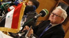 FILE PHOTO: Russia's Deputy Foreign Minister Sergei Ryabkov sits near the Syrian national flag as he addresses a news conference in Damascus June 28, 2014. Ryabkov, on a trip to Damascus, calls for a united effort with the U.S. and Europe to combat milit