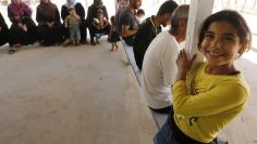 Syrian refugees wait to call their relatives at a centre of the International Committee of The Red Cross which conducts a programme that enables refugees to get in touch with their relatives either by using mobile phones or by writing letters, at Al Zaata