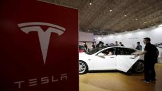 People visit a Tesla Model S car during the Auto China 2016 in Beijing, China, April 25, 2016. REUTERS/Jason Lee/File Photo  