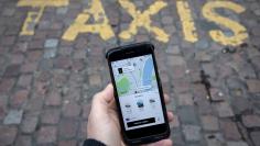 FILE PHOTO: A photo illustration shows the Uber app on a mobile telephone, as it is held up for a posed photograph, in London, Britain, November 10, 2017. REUTERS/Simon Dawson/File Photo