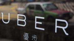 FILE PHOTO -  A taxi is reflected in a window at the office of taxi-hailing service Uber Inc in Hong Kong, China August 12, 2015.   REUTERS/Tyrone Siu/File Photo 