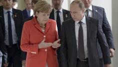 Russian President Vladimir Putin (R) and German Chancellor Angela Merkel walk during a meeting in Rio de Janeiro July 13, 2014.  REUTERS/Alexey Nikolsky/RIA Novosti/Kremlin