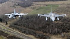 Portuguese Air Force fighter F-16 (R) and Canadian Air Force fighter CF-18 Hornet patrol over Baltics air space, from the Zokniai air base near Siauliai November 20, 2014. REUTERS/Ints Kalnins