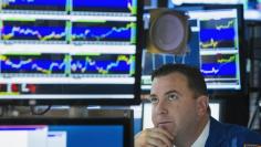 A trader looks up at his screen as he works on the floor of the New York Stock Exchange shortly before the closing of the market in New York, July 11, 2013. REUTERS/Lucas Jackson