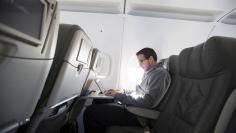 FILE PHOTO: A man uses his laptop to test a new high speed inflight Internet service named Fli-Fi while on a special JetBlue media flight out of John F. Kennedy International Airport in New York, file