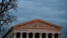 The top of U.S. Supreme Court building is lit at dusk in Washington