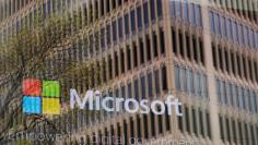 FILE PHOTO: An promotional video plays behind a window reflecting a nearby building at the Microsoft office in Cambridge, Massachusetts, U.S. on May 15, 2017.  To match Special Report USA-COURTSECRECY/HARASSMENT    REUTERS/Brian Snyder/File Photo