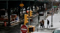 People walk the streets of the Crotona Park East in the Bronx borough of New York