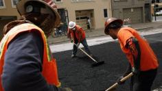 Workers spread asphalt on a street in the Cow Hollow neighborhood in San Francisco, California June 2, 2010. REUTERS/Robert Galbraith