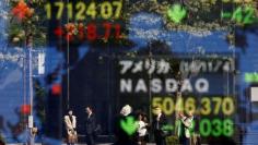 People are reflected in a display showing the Nikkei average (top in L) and the NASDAQ average of the U.S outside a brokerage in Tokyo, Japan, November 7, 2016. REUTERS/Kim Kyung-Hoon - S1AEULJVTGAA