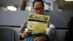 File photo of Murillo reading a leaflet on Obamacare at a health insurance enrollment event in Cudahy, California