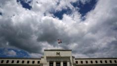 Flags fly over the Federal Reserve Headquarters on a windy day in Washington, U.S., May 26, 2017. REUTERS/Kevin Lamarque