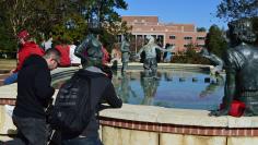 Josh Nieves, 20, a music student from Fort Myers (L) and Tim Kehl, 19, a junior finance student from Tallahassee, kneel at the fountain in front of the library and pray at Florida State University, in Tallahassee, Florida, November 20, 2014. REUTERS/Bil C
