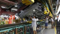 Assembly workers work on the underside of 2015 Ford Mustang vehicles on the production line at the Ford Motor Flat Rock Assembly Plant in Flat Rock, Michigan, August 20, 2015.  REUTERS/Rebecca Cook