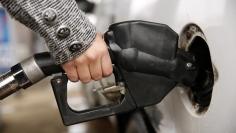 A woman pumps gas at a station in Falls Church, Virginia December 16, 2014.  REUTERS/Kevin Lamarque  