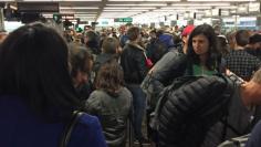 People queue at the immigration lines during a systems outage at Sea-Tac Airport in Seattle