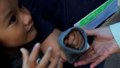 FILE PHOTO: An ethnic Chinese Christian, who fled Indonesia after wide scale rioting and overstayed her visa in the U.S., holds her daughter's hand and a handwritten list of appointments with ICE in Manchester, New Hampshire, U.S., October 13, 2017.  REU