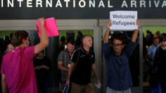 FILE PHOTO: Retired engineer John Wider, 59, is greeted by a supporter of U.S. President Donald Trump as he holds up a sign reading "Welcome Refugees" at the international arrivals terminal at Los Angeles International Airport in Los Angeles, California,