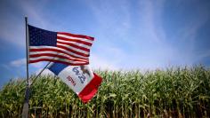 File photo of a U.S. and Iowa state flag are seen next to a corn field in Grand Mound