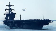 FILE PHOTO - Sailors man the rails of the USS Carl Vinson, a Nimitz-class aircraft carrier, as it departs its home port in San Diego, California August 22, 2014. REUTERS/Mike Blake/File Photo