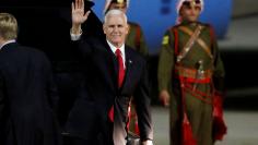 U.S. Vice President Mike Pence waves to the media after his arrival at Amman military airport