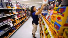 Walmart department manager Karren Gomes helps stock shelves with school supplies as the retail store prepare for back to school shoppers in San Diego, California