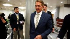 FILE PHOTO: Senator Jeff Flake (R-AZ) walks with reporters after speaking in the Senate on Capitol Hill in Washington, U.S., January 17, 2018.      REUTERS/Joshua Roberts