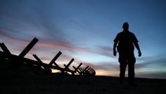 U.S. border patrol agent Alessio Faccin walks along the border fence separating Mexican from the United States near Calexico, California