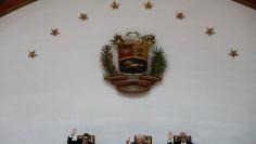 Lawmakers of the Venezuelan coalition of opposition parties (MUD) Julio Cesar Reyes, first vice president, Omar Barboza, president of the National Assembly and Alfonso Marquina, second vice president, vote during a session of the National Assembly, in Ca