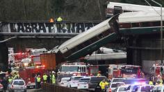 First responders are at the scene of an Amtrak passenger train which derailed and is hanging from a bridge over the interstate highway (I-5) in DuPont, Washington, U.S., December 18, 2017.    REUTERS/Nick Adams