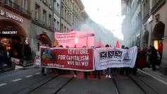 Protesters with banners light a flare during an anti-WEF and anti-U.S. President Trump demonstration in Bern