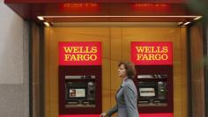 File photo of a woman walking past teller machines at a Wells Fargo bank in San Francisco