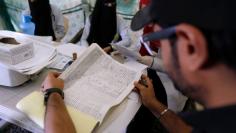 Health worker reviews a list of patients admitted to a cholera treatment center in Sanaa, Yemen