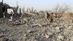 People walk at the site of an air strike that destroyed a house and a clinic attached to it on the outskirts of the northwestern city of Saada, Yemen January 22, 2018. REUTERS/Naif Rahma