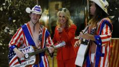 Kellyanne Conway, campaign manager and senior advisor to the Trump Presidential Transition Team, converses with "Naked Cowboy" themed street performers in the lobby at Trump Tower in New York