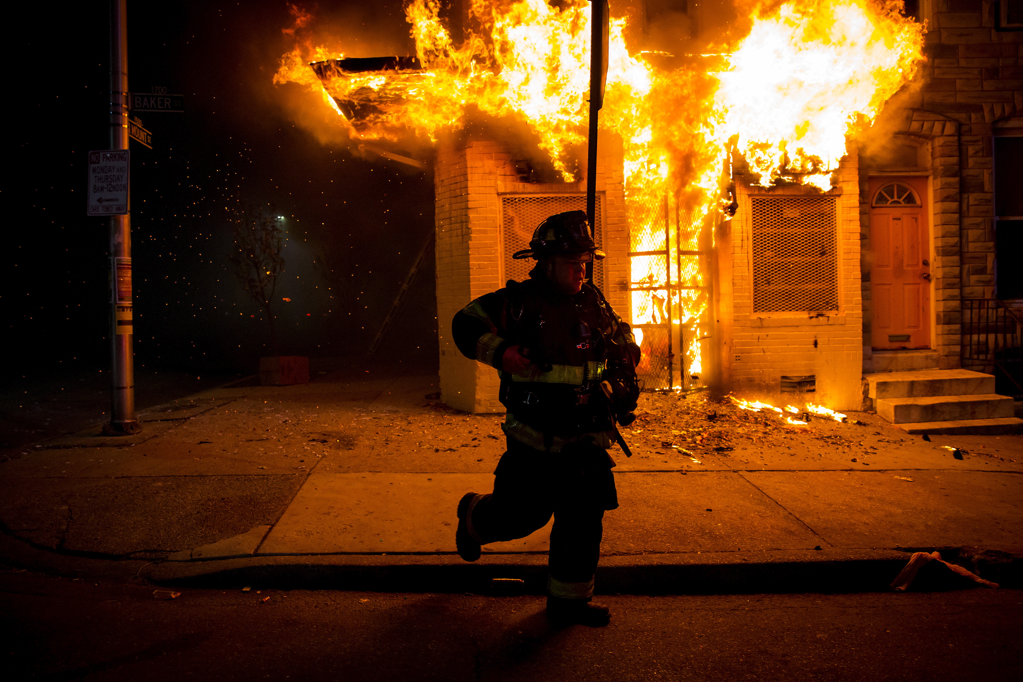 Baltimore firefighters attack a fire in a convenience store and residence during clashes after the funeral of Freddie Gray in Baltimore, Maryland