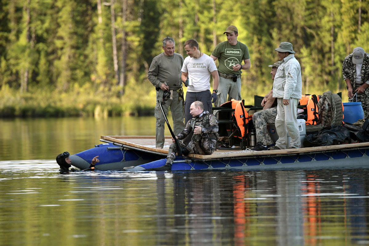 Russian President Vladimir Putin and and Defence Minister Sergei Shoigu float in a boat while they fish during the hunting and fishing trip which took place on August 1-3 in the republic of Tyva in southern Siberia