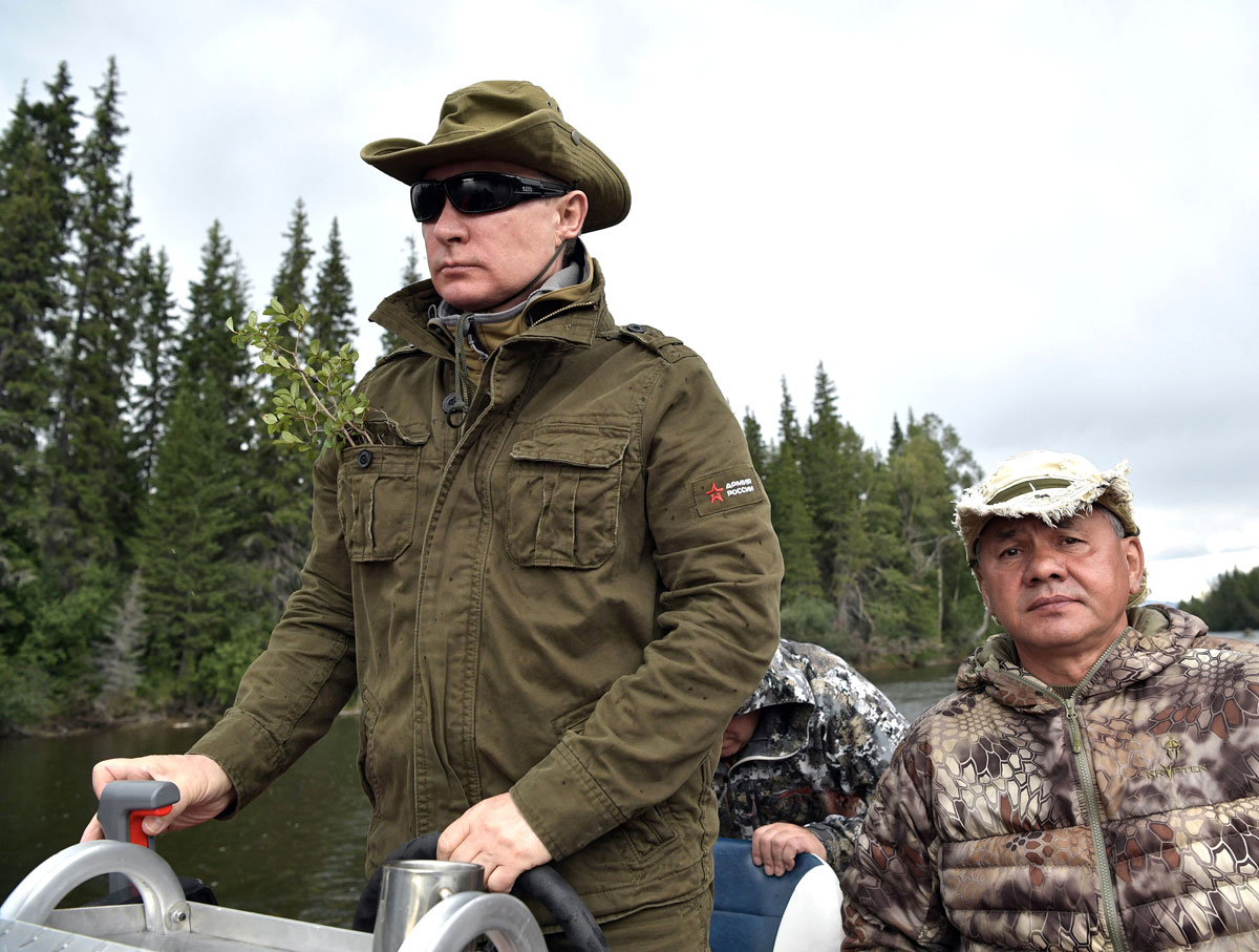 Russian President Vladimir Putin and Defence Minister Sergei Shoigu ride a boat during the hunting and fishing trip which took place on August 1-3 in the republic of Tyva in southern Siberia