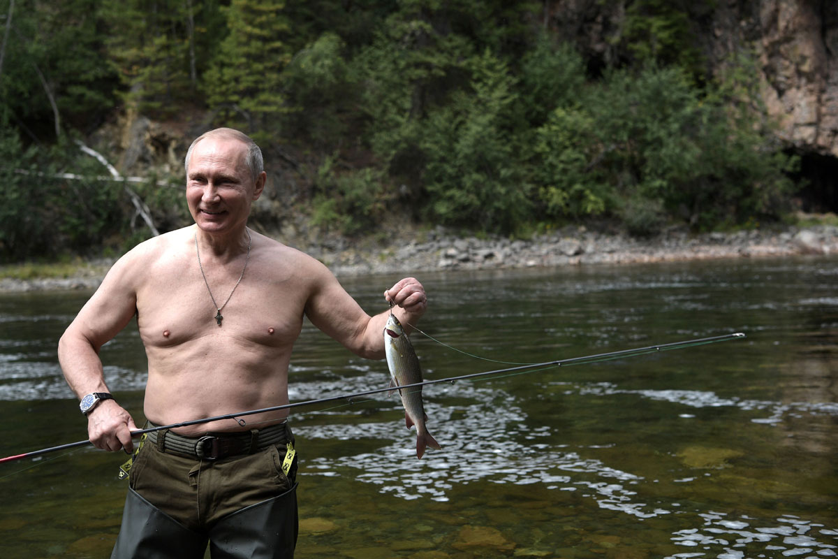 Russian President Vladimir Putin holds a fish he caught during the hunting and fishing trip which took place on August 1-3 in the republic of Tyva in southern Siberia