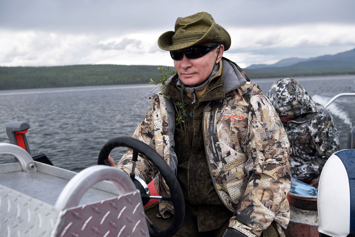 Russian President Vladimir Putin drives a boat during the hunting and fishing trip which took place on August 1-3 in the republic of Tyva in southern Siberia