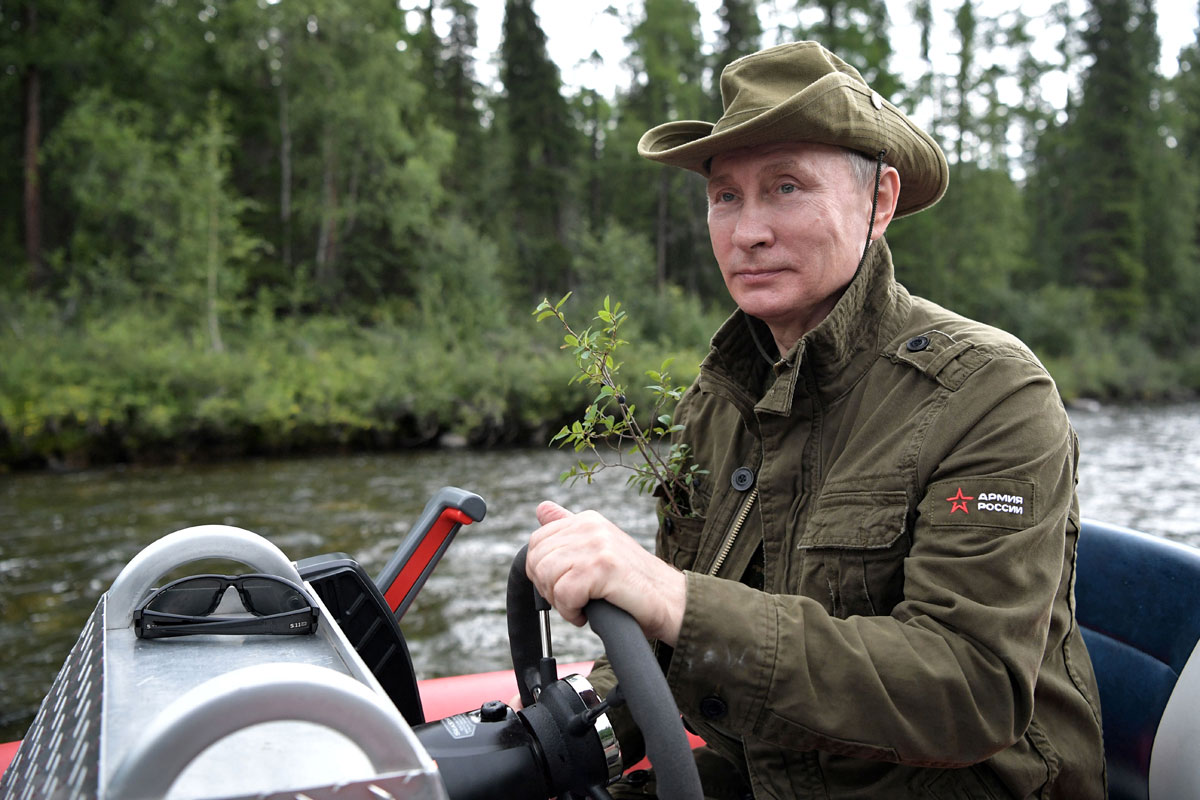 Russian President Vladimir Putin controls a boat during the hunting and fishing trip which took place on August 1-3 in the republic of Tyva in southern Siberia