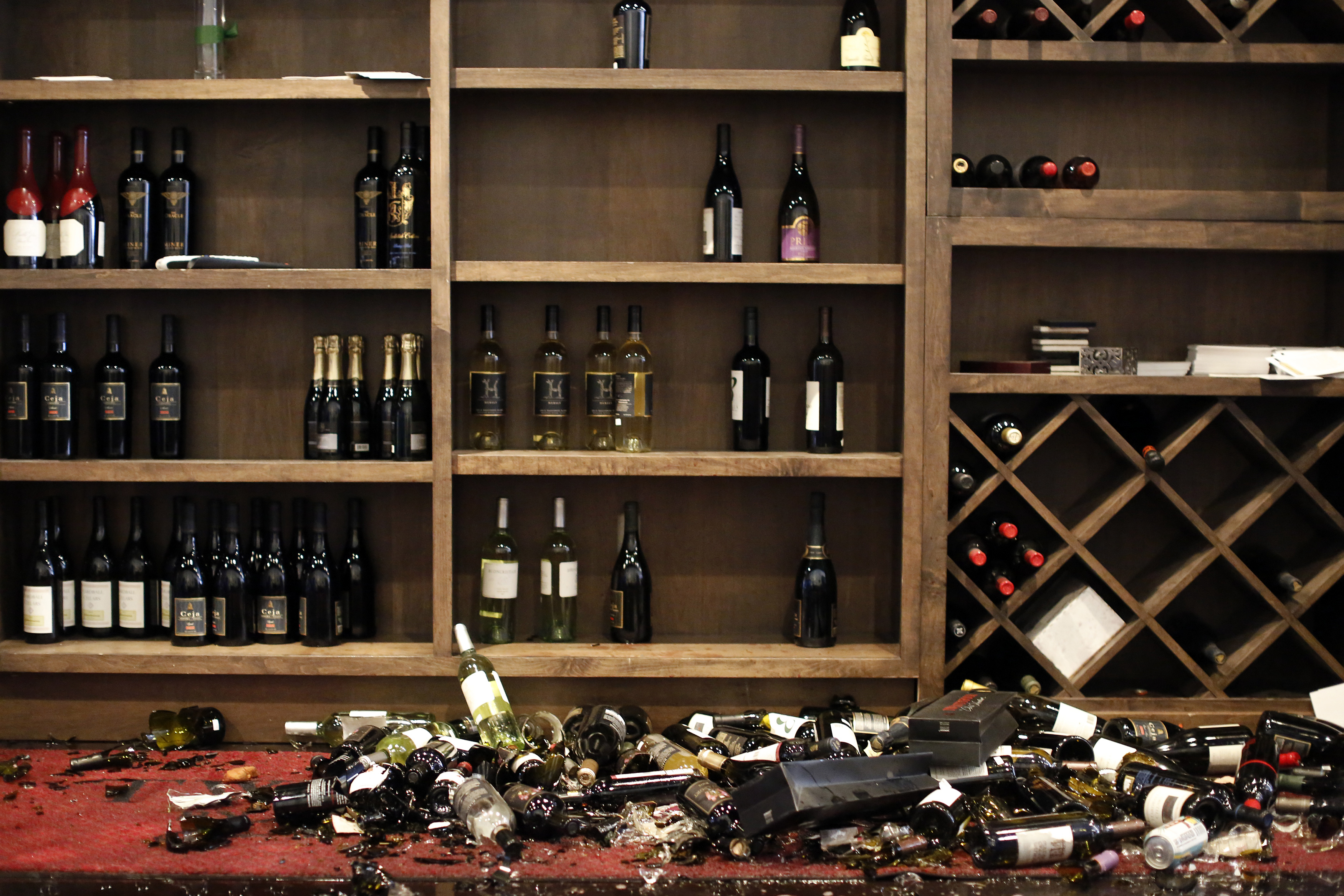 Fallen wine bottles are seen at Cult Following Wine Bar after an earthquake in Napa, California