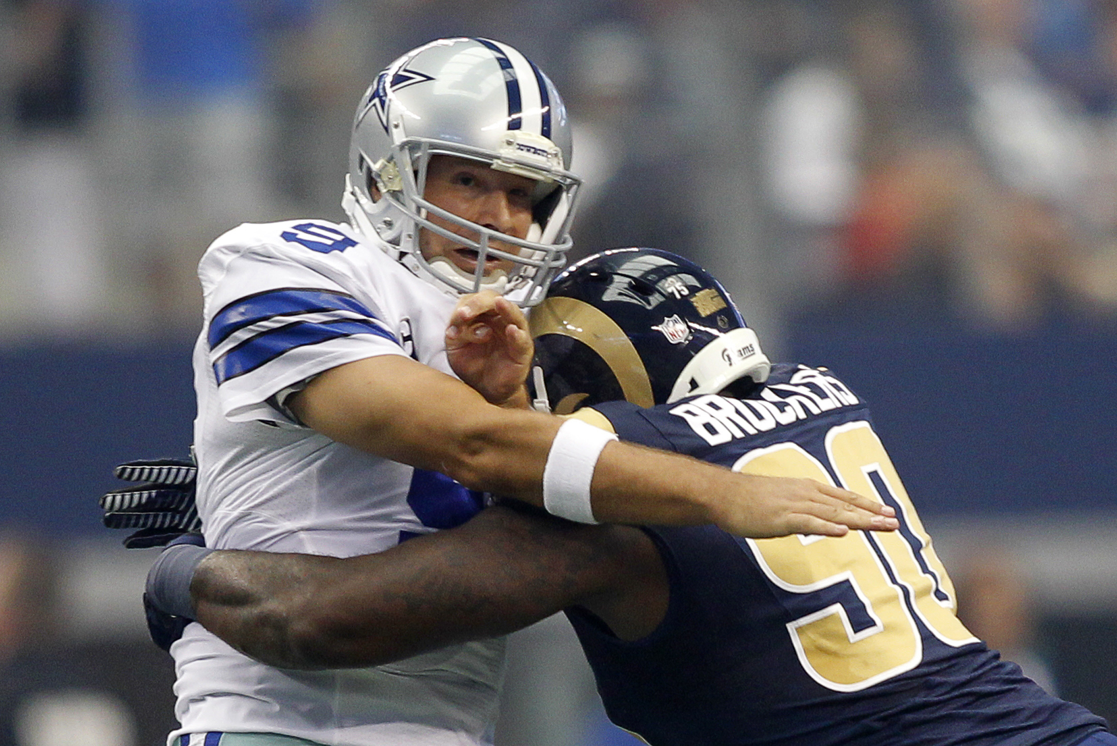 Dallas Cowboys quarterback Tony Romo is hit by St. Louis Rams defensive tackle Michael Brockers in Arlington, Texas
